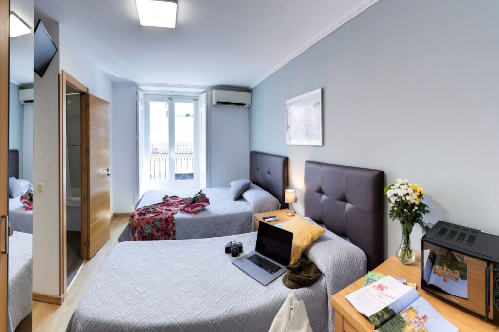Vista completa de una habitación doble de Hostal Patria, con camas, escritorio y balcón